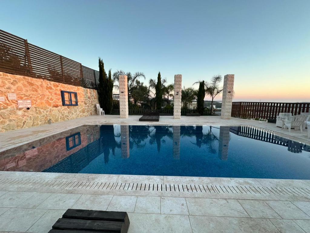 a swimming pool in front of a house at carmel cabins suite nu 9 in Yājur