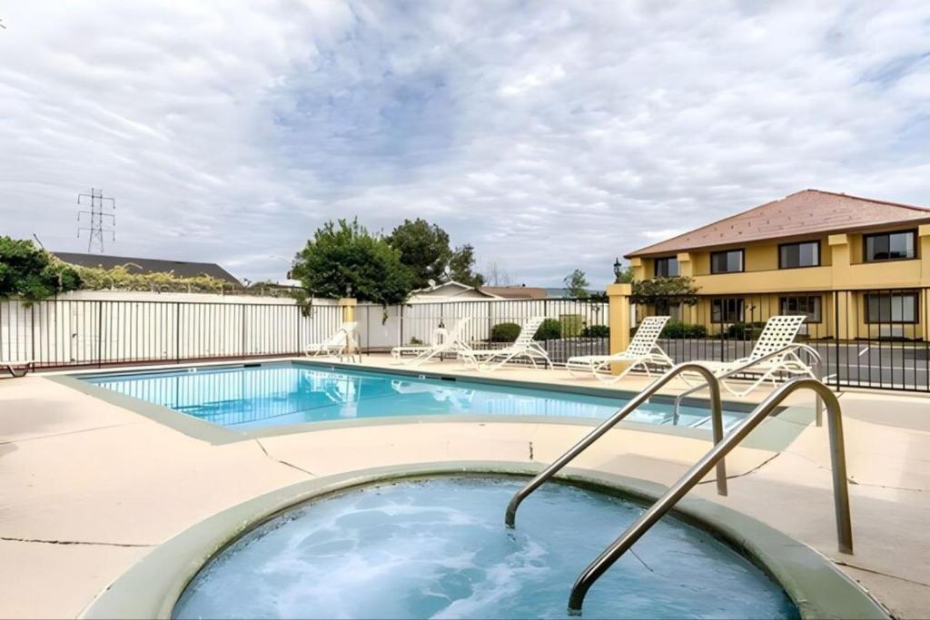 a swimming pool with chairs and a building at Quality Inn & Suites Gilroy in Gilroy