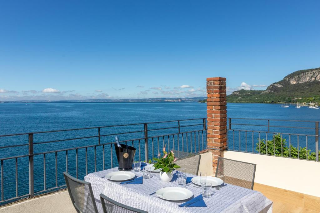 a table on a balcony with a view of the water at Casa Bortolo in Garda