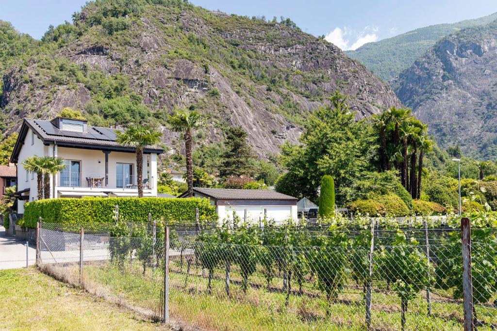 a house with a fence in front of a mountain at Casa QUATTRO FIUMI in Tegna