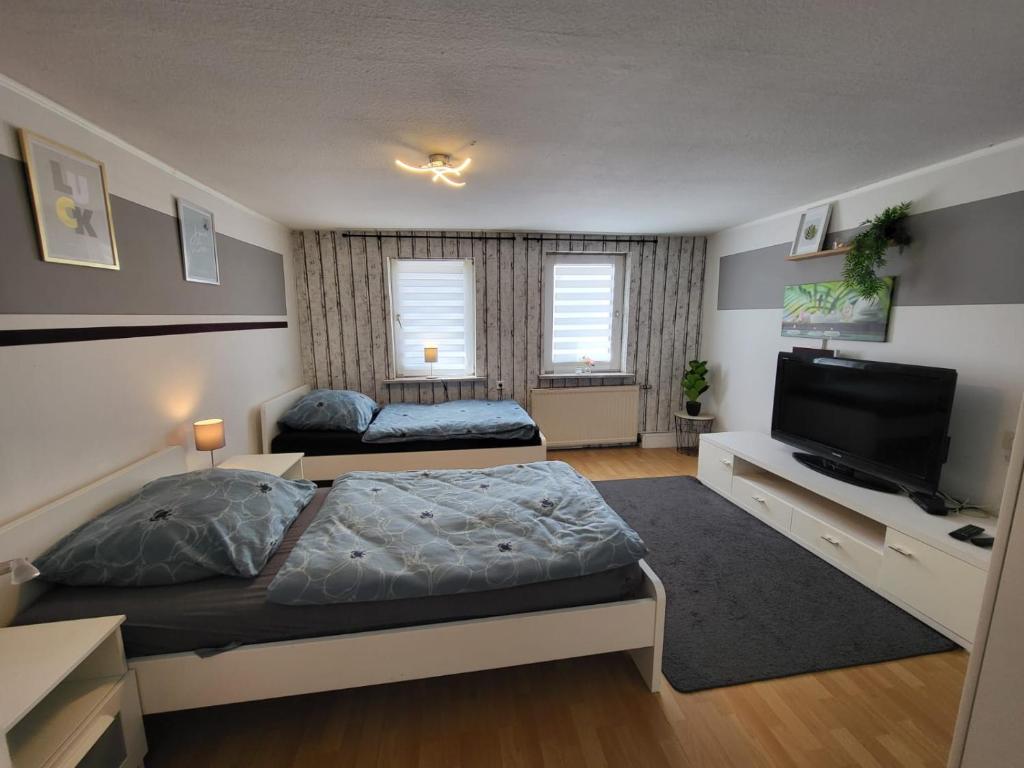 a bedroom with a bed and a flat screen tv at Worker's Home by Nina in Herzberg am Harz