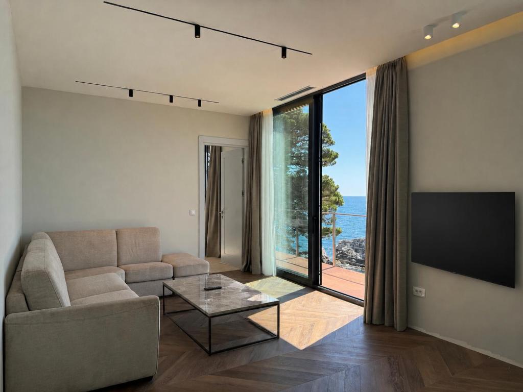 a living room with a couch and a large window at Beachfront Luxury Villa - Bar in Bar