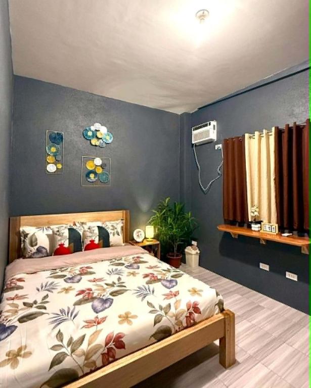 a bedroom with a bed and a blue wall at Shanti's Inn in General Luna