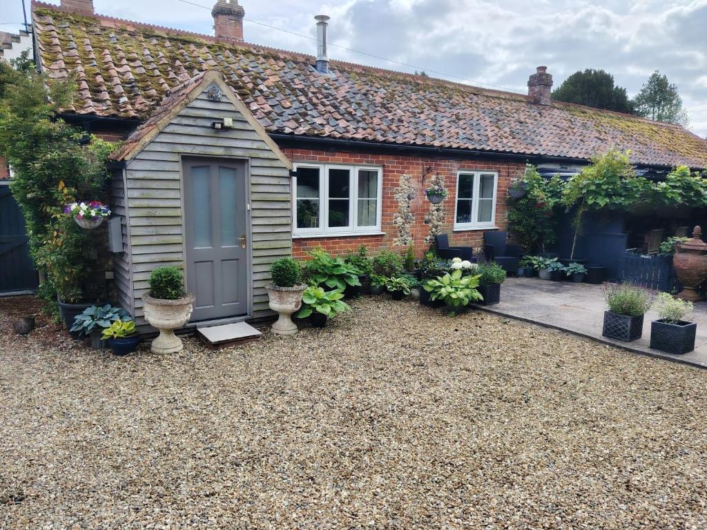 a small house with a garden in front of it at Cosy Cottage in North Elmham