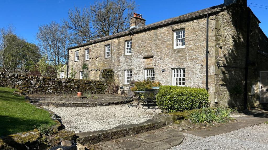 an old brick house with a stone wall at Tarn House in Hawes