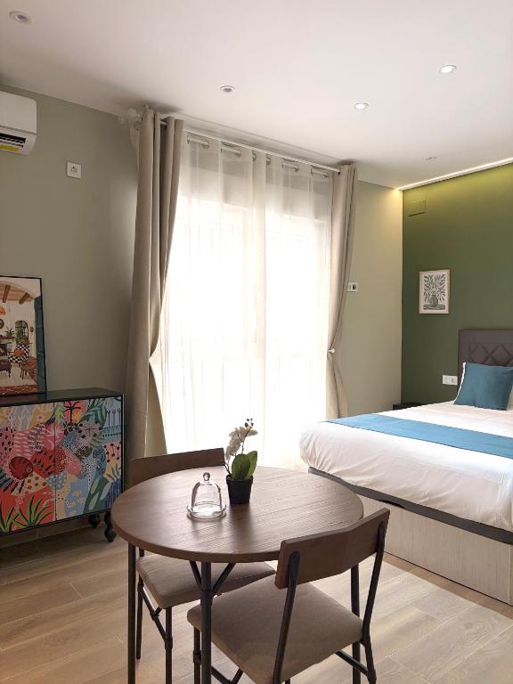 a bedroom with a bed and a table and a bed at Feliz Apartment in Madrid