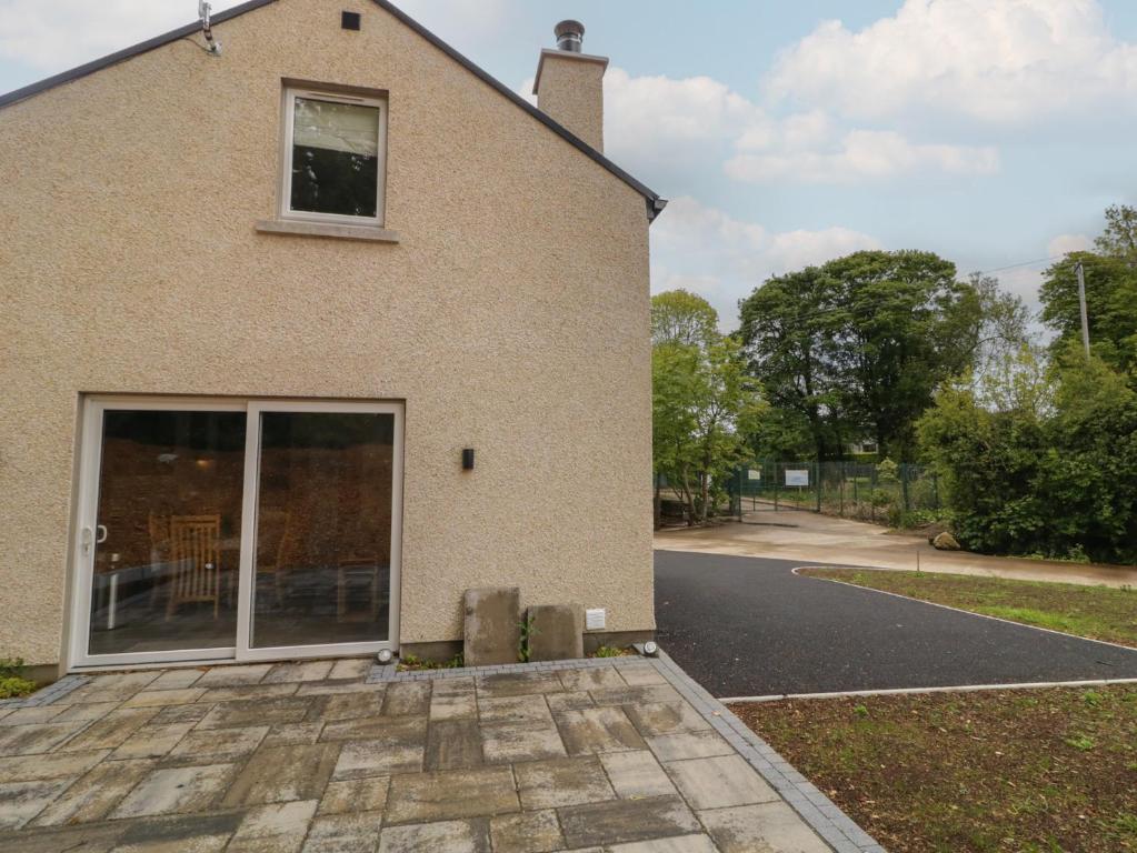 a house with a large glass door on a street at Brook Cottage in Coleraine