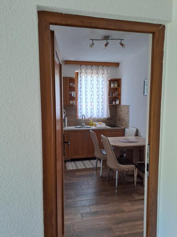 a kitchen and dining room with a table and chairs at Apartmani Sorić in Prijeboj