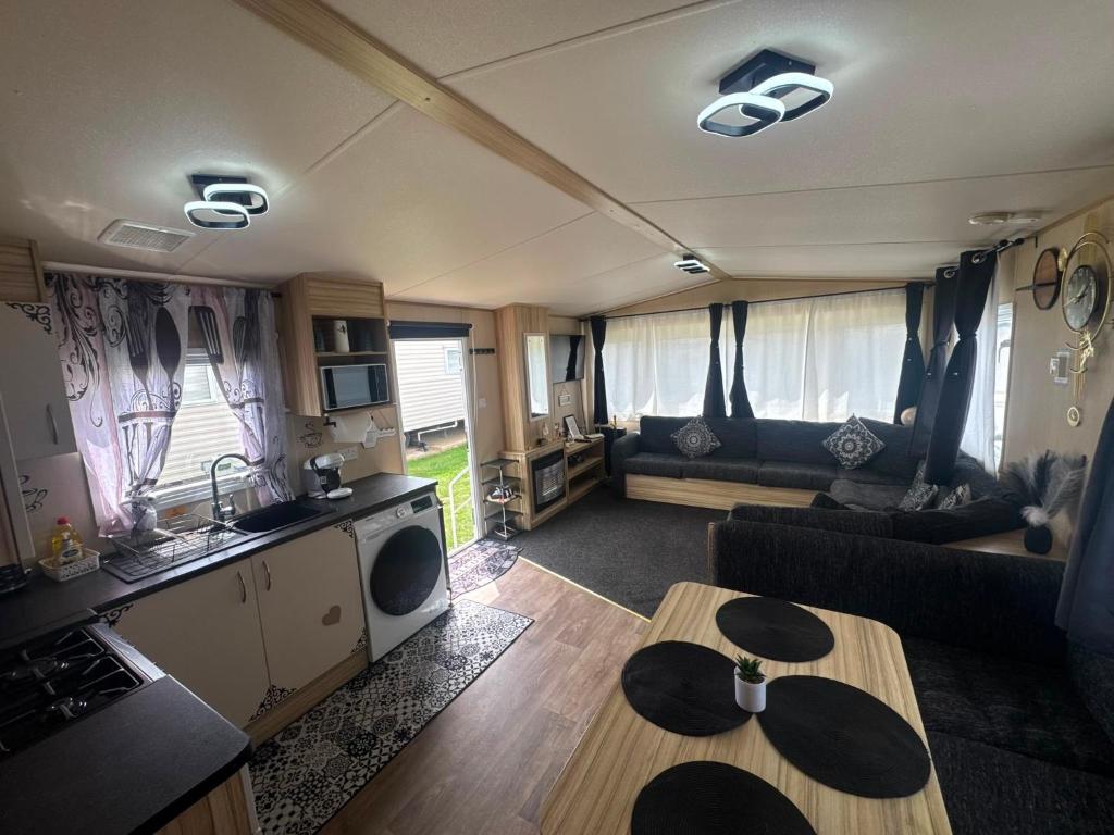 a living room with a couch and a table at Holiday Park Caravan Fluffy in Harts Holiday Park in Leysdown-on-Sea