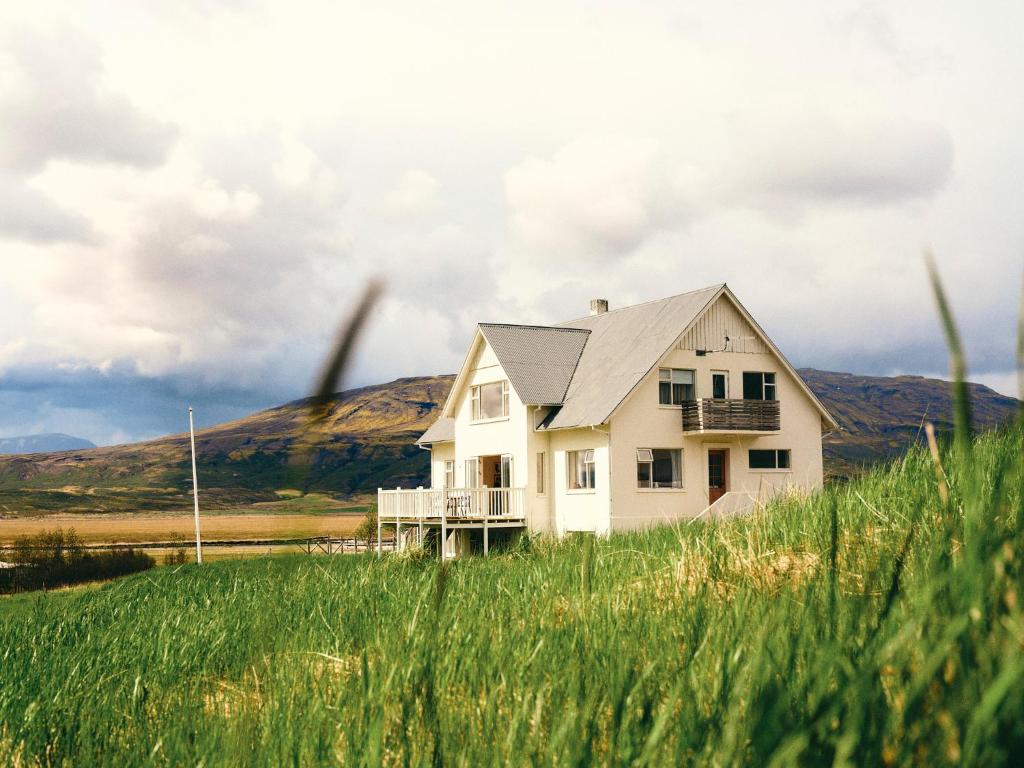a house in the middle of a field of grass at Kjarnholt in Kjarnholt