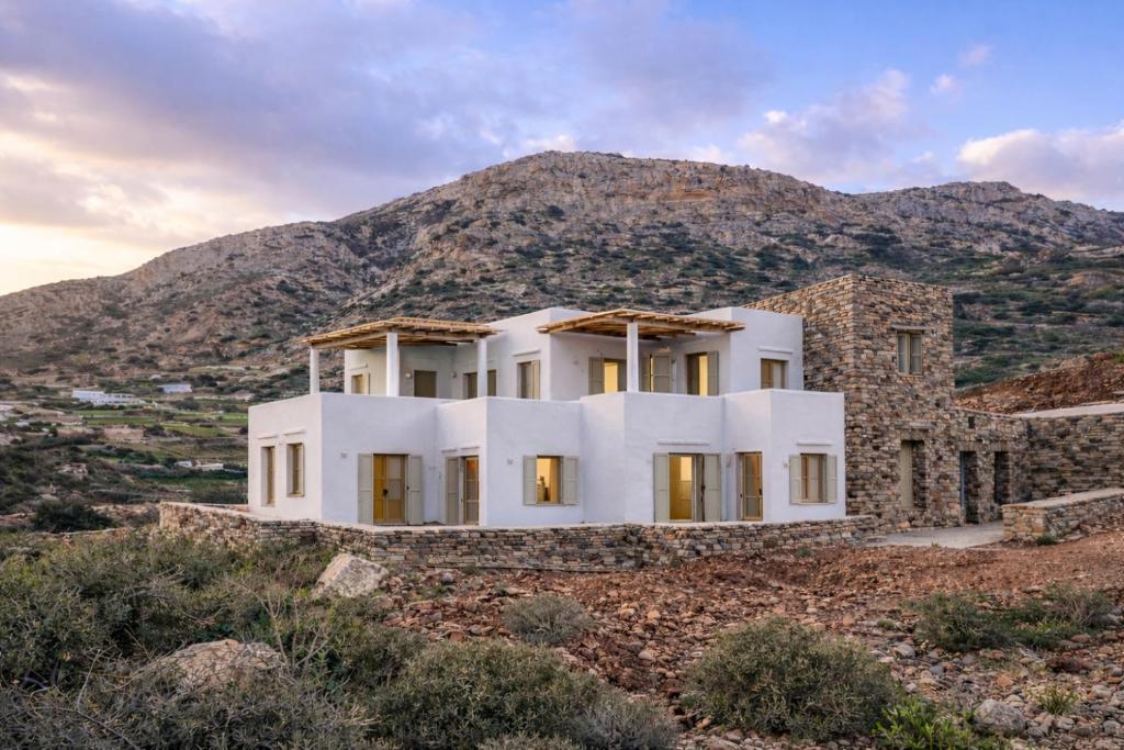 a white house on a hill with a mountain at Thyme Timeless Stay in Kamares