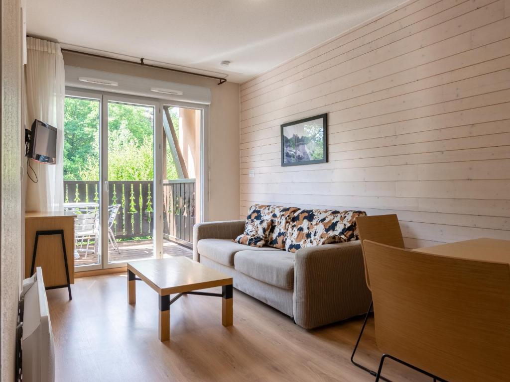 a living room with a couch and a window at Les Chalets d Ax N212 - 2P6C in Ax-les-Thermes