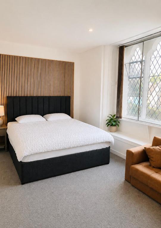 a bedroom with a large bed and a couch at Snowdon Apartments in Stirling