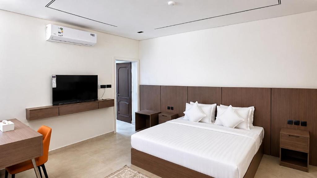 a bedroom with a bed and a desk and a television at OrbitNet - Anwarat in Medina