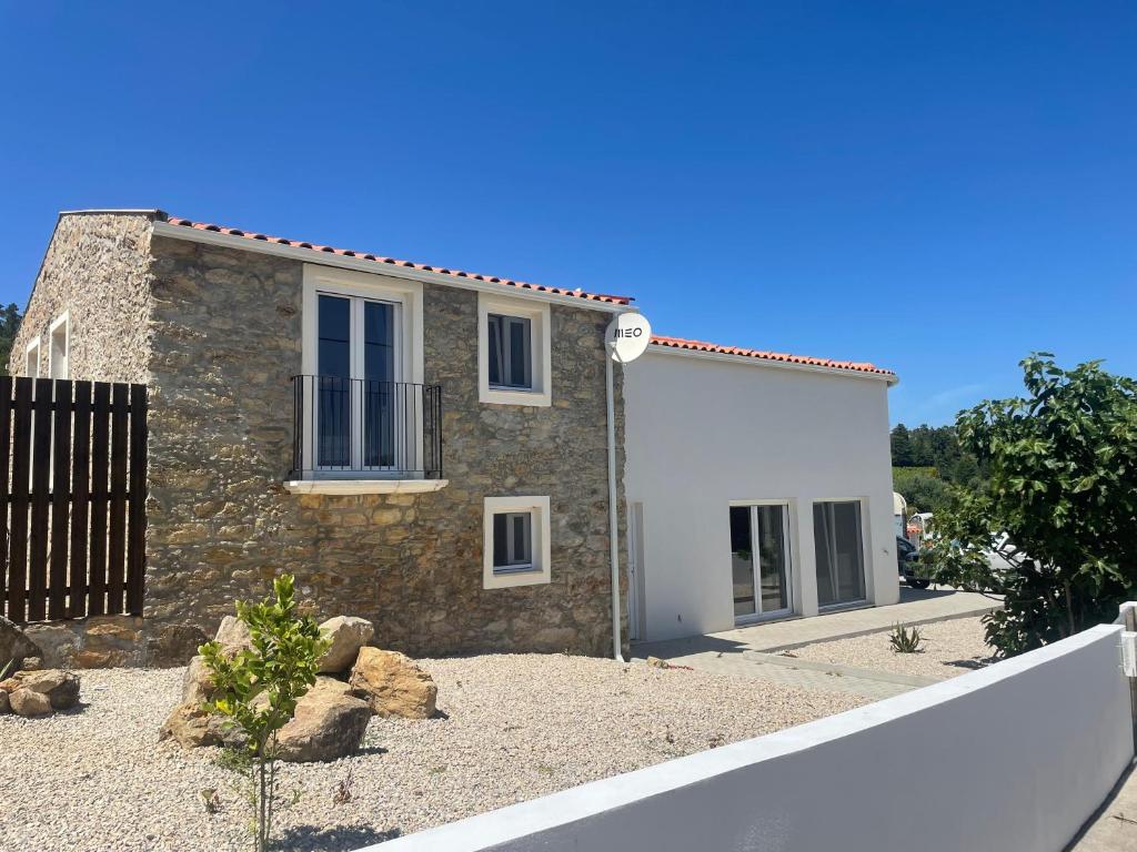 a stone house with a fence in front of it at Casa Borboleta in Chão de Lamas