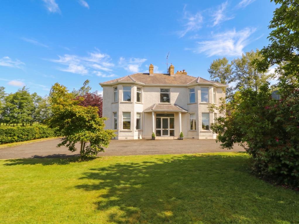 a large white house with a large yard at Riverdene in Omagh