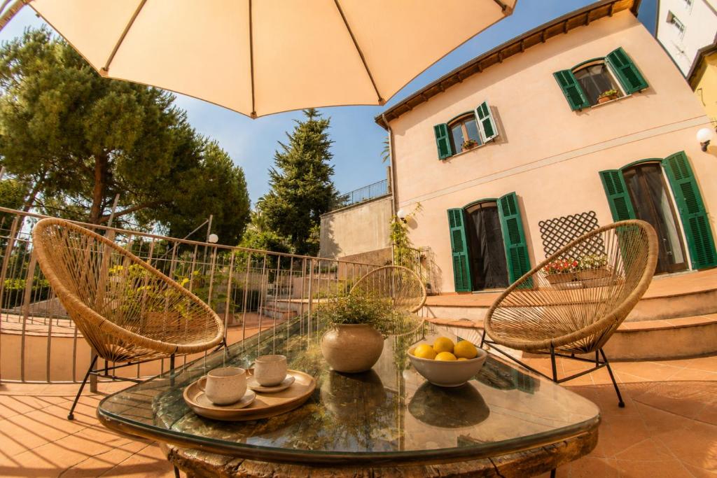 a patio with a table and chairs and an umbrella at Officine Bordighera in Bordighera
