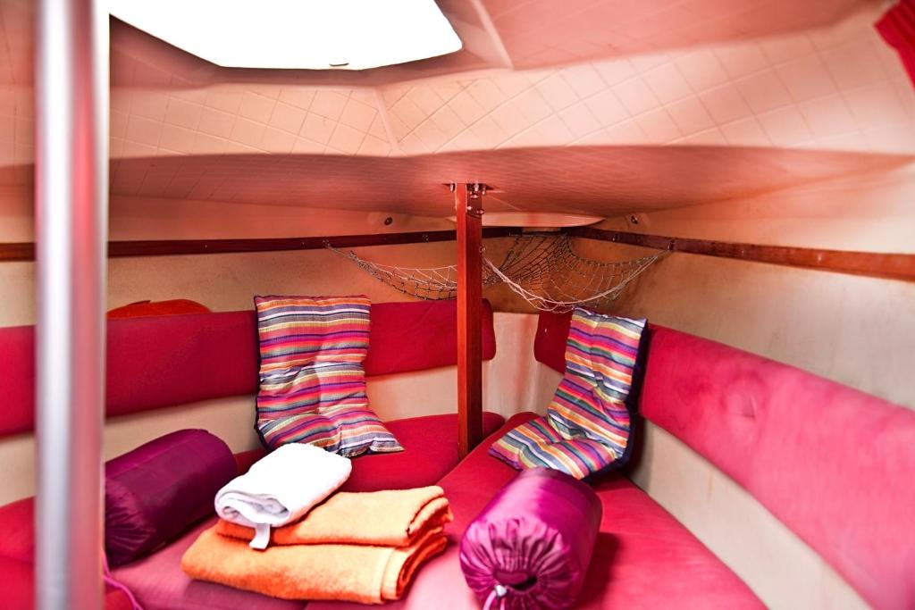 Bett in einem Zimmer mit lila und rosa Möbeln in der Unterkunft VRS - Low Cost Beach Boat in Leça da Palmeira