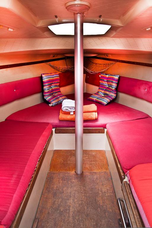 a small boat with red cushions and a pole at VRS - Low Cost Beach Boat in Leça da Palmeira
