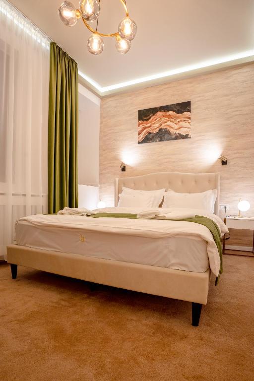 a bedroom with a large bed with a green curtain at Luna Boutique in Bucharest