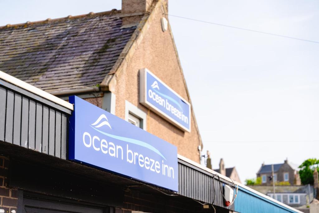 a sign for an ocean breeze inn on the side of a building at Ocean Breeze Inn in Eyemouth