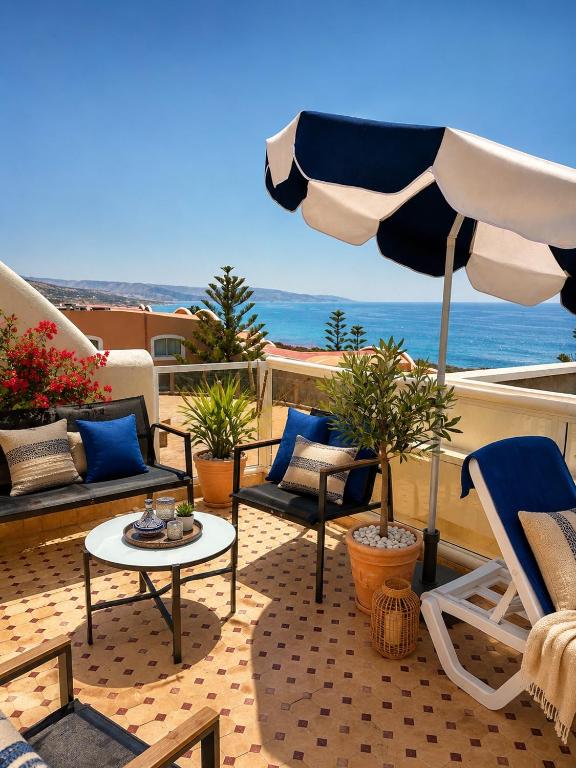 a patio with chairs and a table and an umbrella at Luxury Villa Ocean View with pool in Tiguert