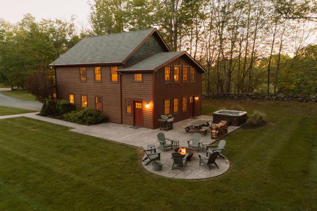 a large log cabin with a patio and a grill at Hot Tub Fire Pit Mountain Retreat Deer Meadows in Jeffersonville