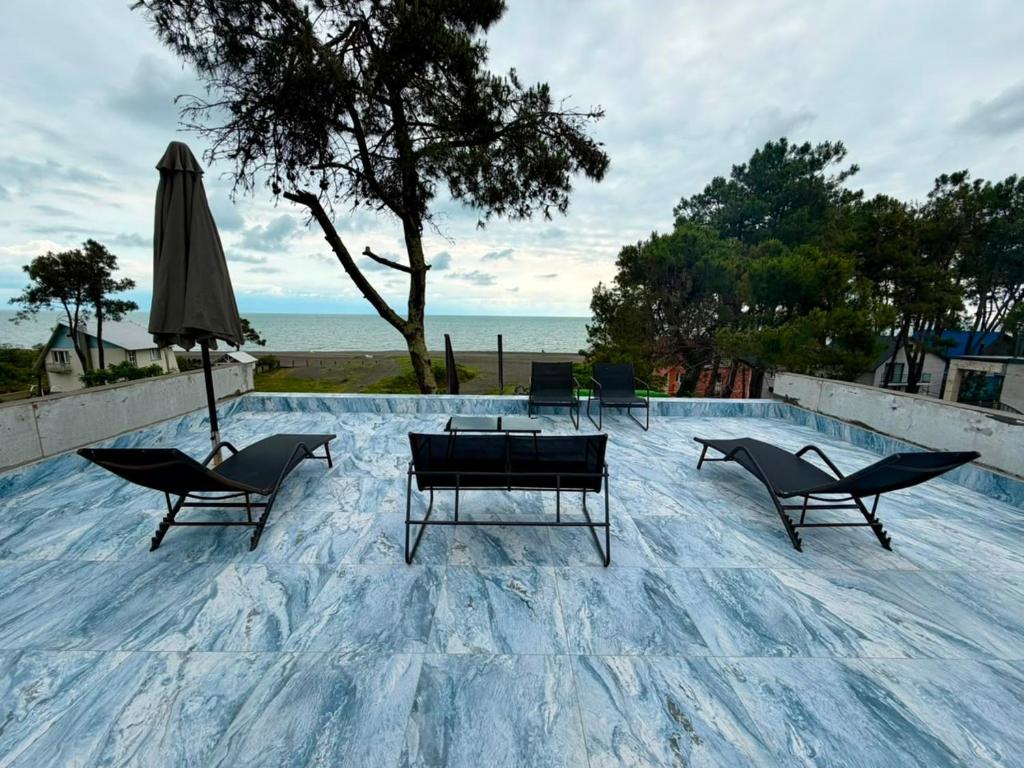 a group of chairs and a table and an umbrella at Sunrise Panorama Terrace in Ozurgetʼi