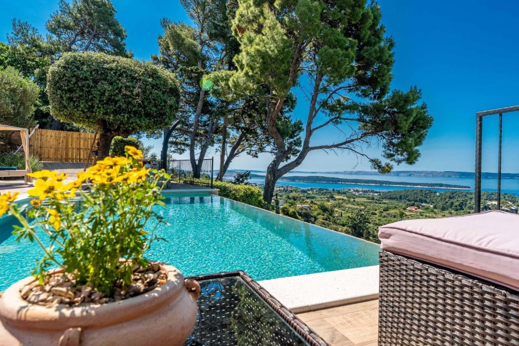 a villa with a swimming pool with a view of the ocean at Holiday house Pantovčak, secluded stone house without other guests,with heated pool and unique view in Rab