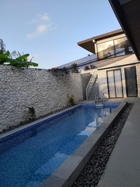 a swimming pool in front of a house at Sonne Villa in Pangandaran