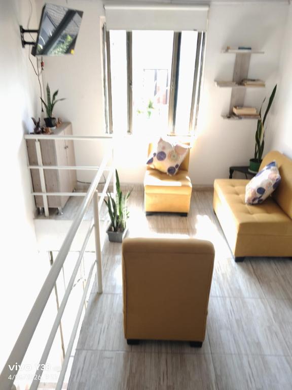 a living room with two couches and a staircase at Apartamento completo Santa Rosa de Cabal in Santa Rosa de Cabal