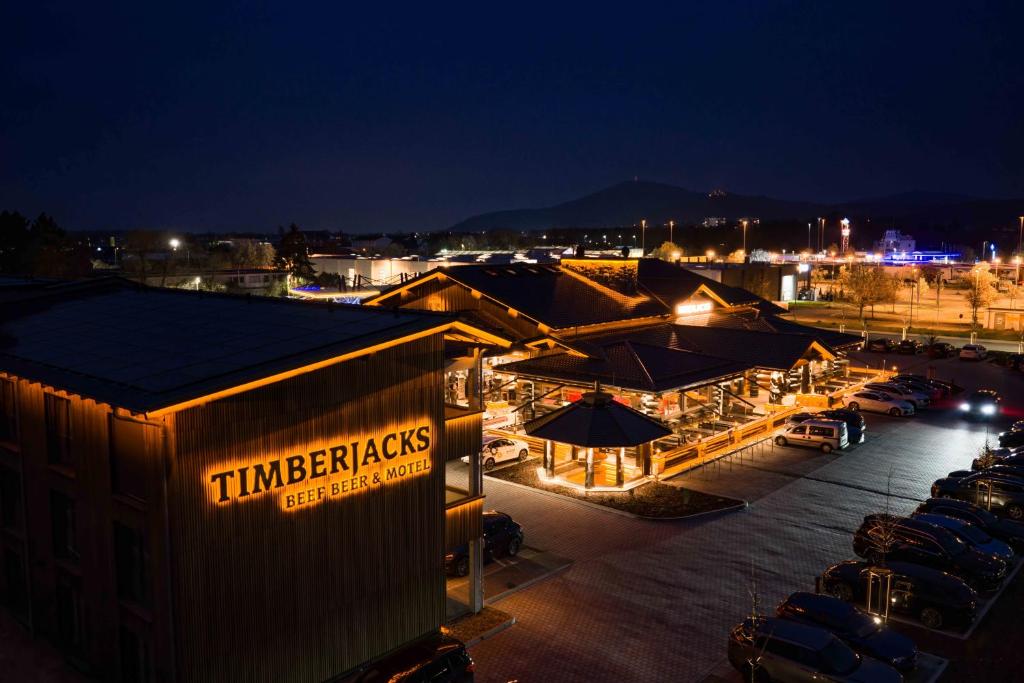 ein Restaurant mit Autos, die nachts auf einem Parkplatz stehen. in der Unterkunft Timberjacks Bensheim Hotel in Bensheim