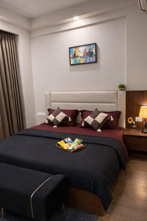 a bedroom with a bed with a tray on it at Sunbliss Corner in Greater Noida