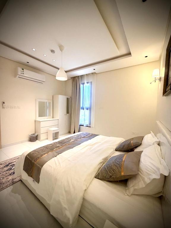 a bedroom with a large bed in a room at شقق واحة المحمدية in Baljurashi