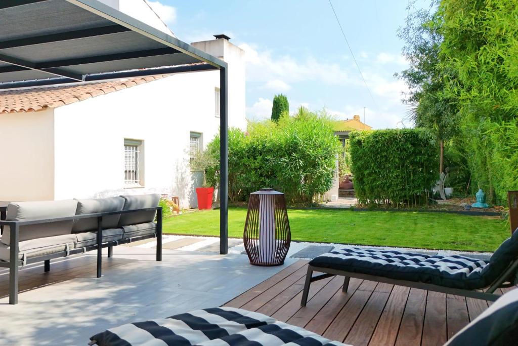 a patio with two benches on a wooden deck at La Cabane du Cap - Jacuzzi & City Center Nearby in Aix-en-Provence