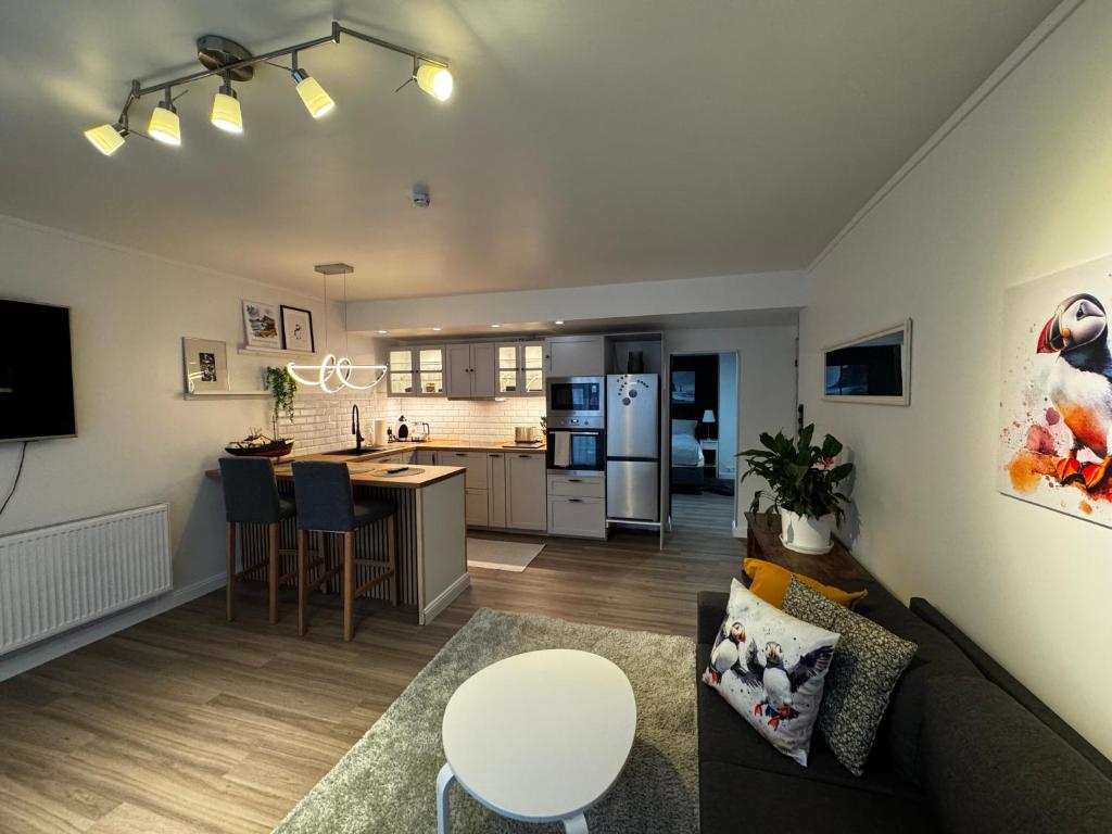 a living room with a couch and a kitchen at Puffin rock in Vestmannaeyjar