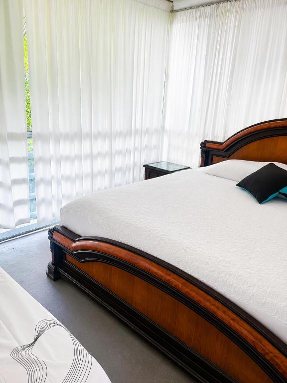 a bedroom with a large bed and a window at Huiltana ecohotel&resort in Guataquí