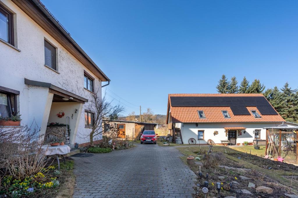 a driveway leading to a house and a house with a car at FeWo Spreequelle in Herrnhut