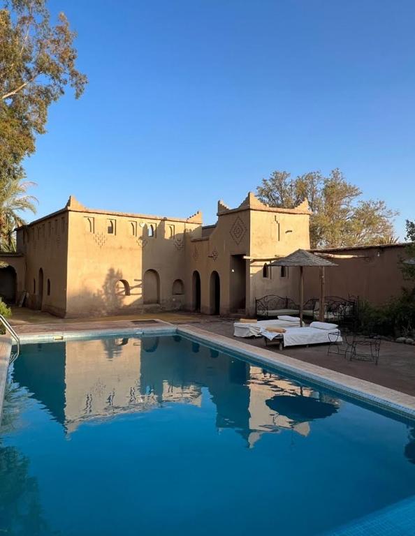 a large swimming pool in front of a building at Dar Es Salam in Skoura