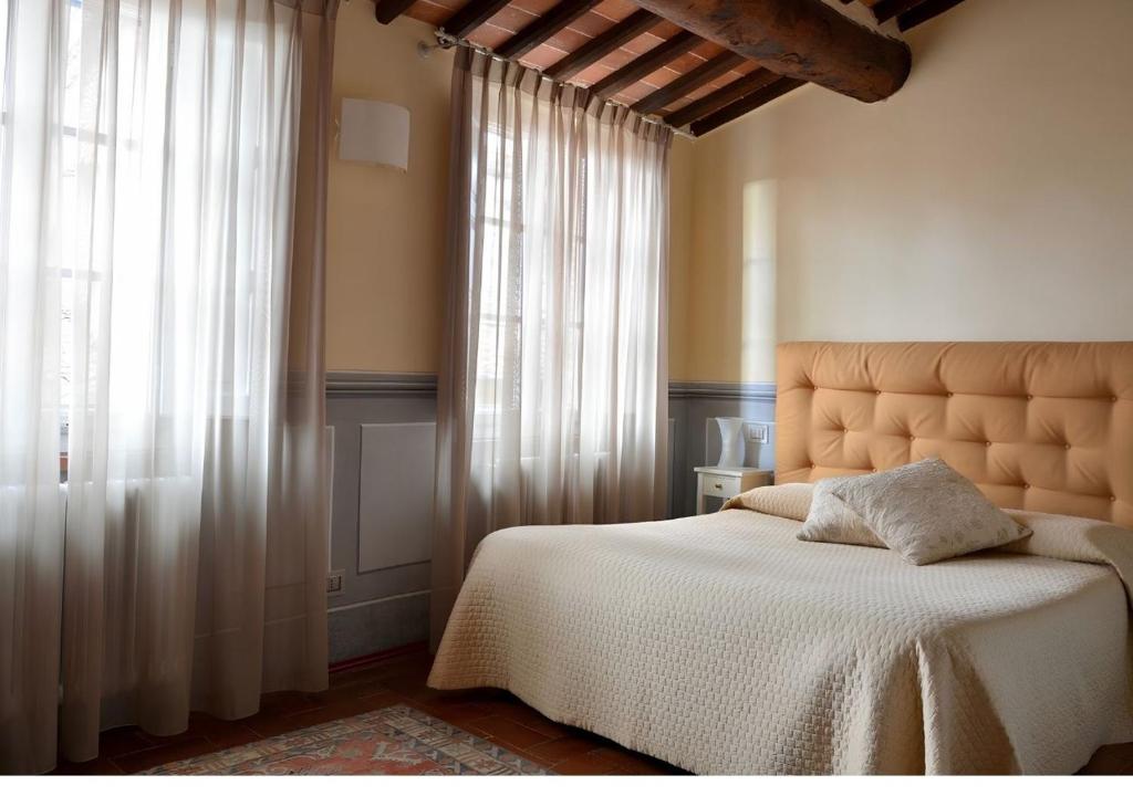 a bedroom with a bed and a large window at Antica Residenza Dell'Angelo in Lucca