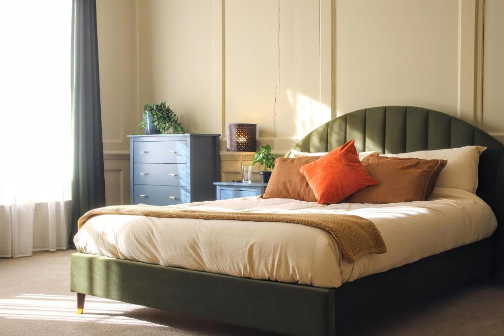a bedroom with a green bed with pillows on it at SixCheapStreet in Newbury