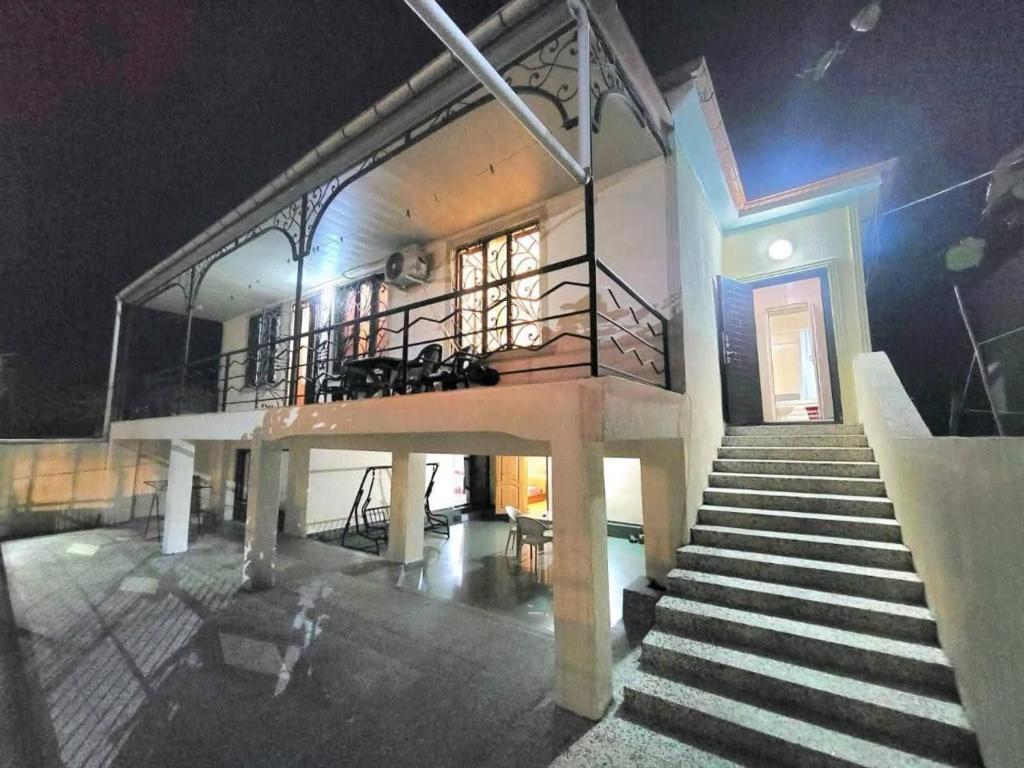 a house with a staircase leading to a building at night at Дом in Kobuleti