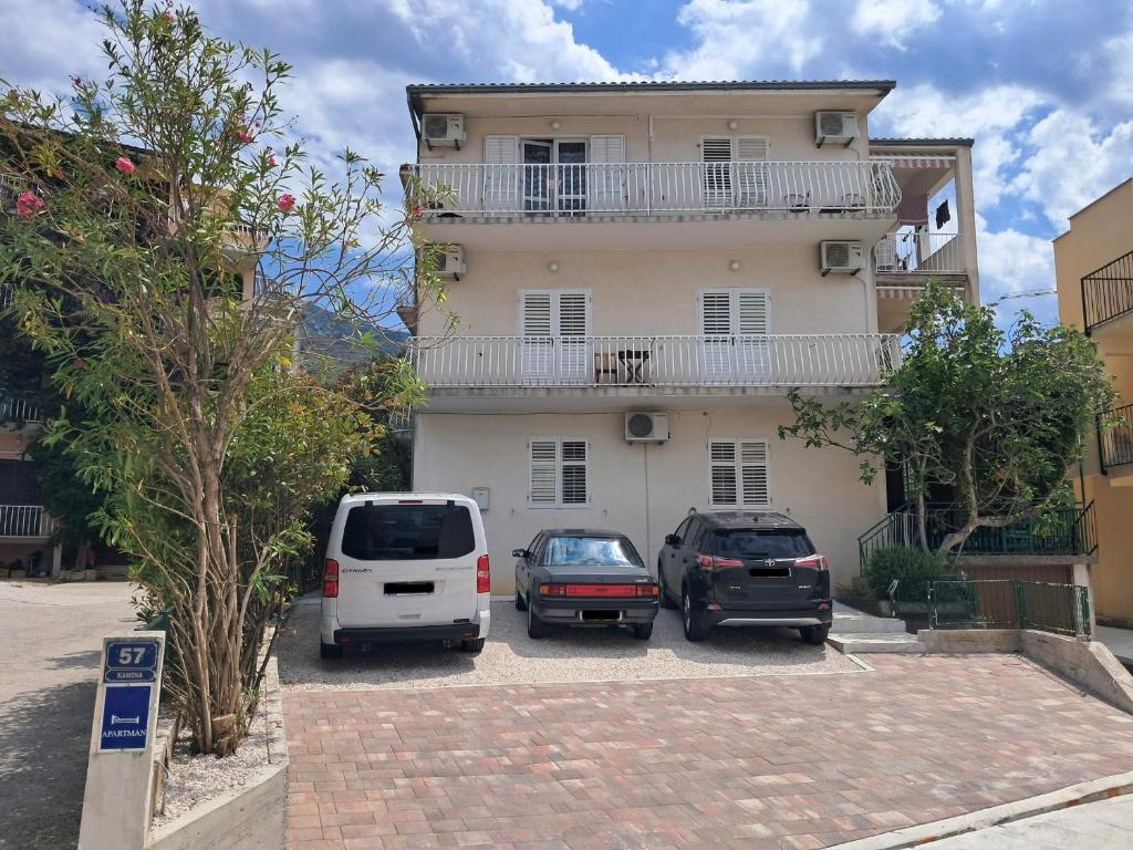 two cars parked in a parking lot in front of a building at Tucepi Kamena 57 in Tučepi