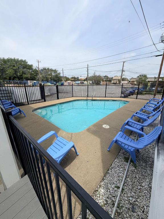 a pool with blue lounge chairs next to a fence at 23 B ST APARTMENTS in Hampton