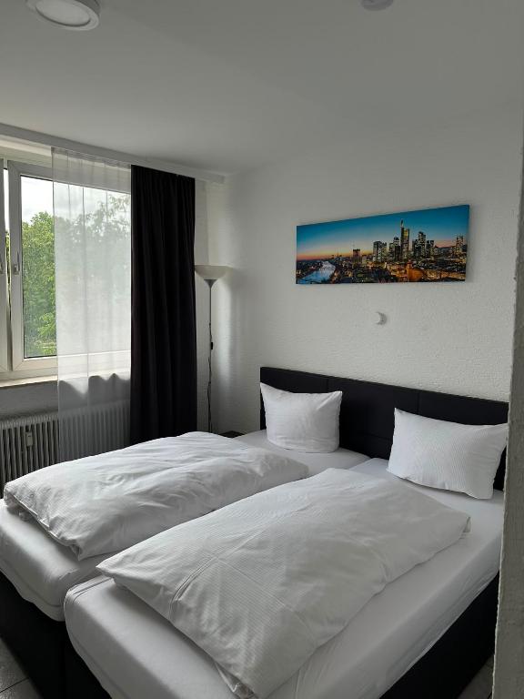 a bedroom with a bed with white sheets and a window at Hotel Main Taunus in Hochheim am Main