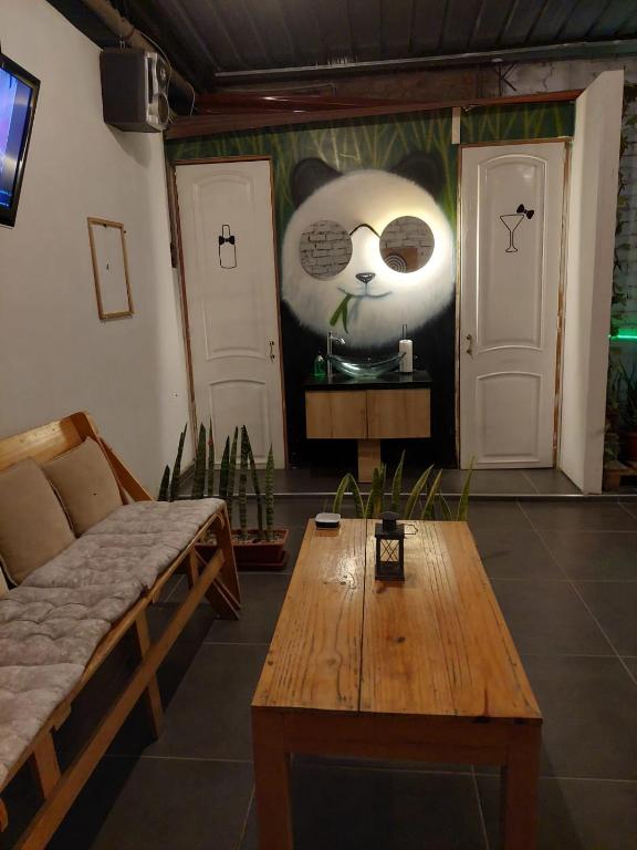 a room with a table and a panda face on the wall at JUMANA in Nazca