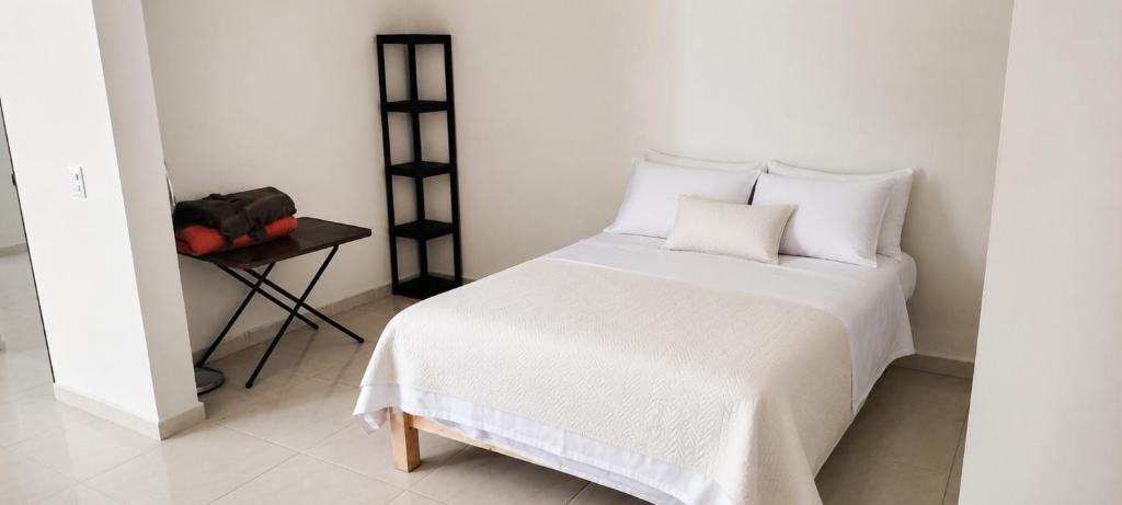a bed with white sheets and pillows in a room at Casa Oasis Aguascalientes in Cañada del Rodeo