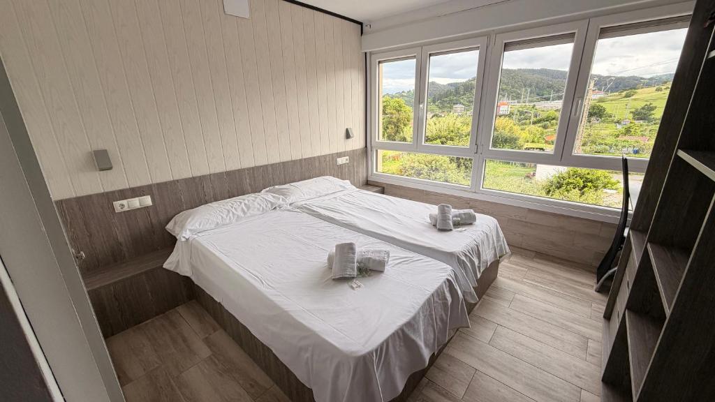 a bedroom with a bed with two glasses on it at Pension GAZTELUGATXE in Bermeo