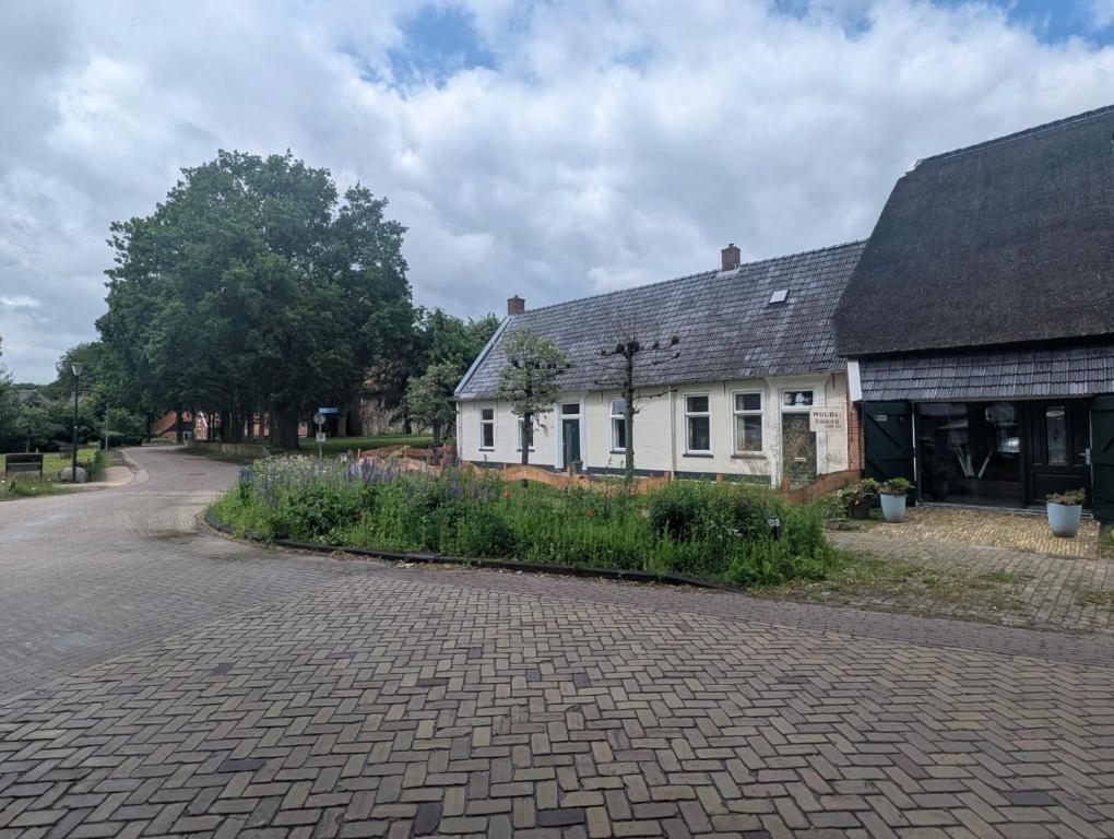 a white house with a brick road in front at Het Schultehuis in Anloo