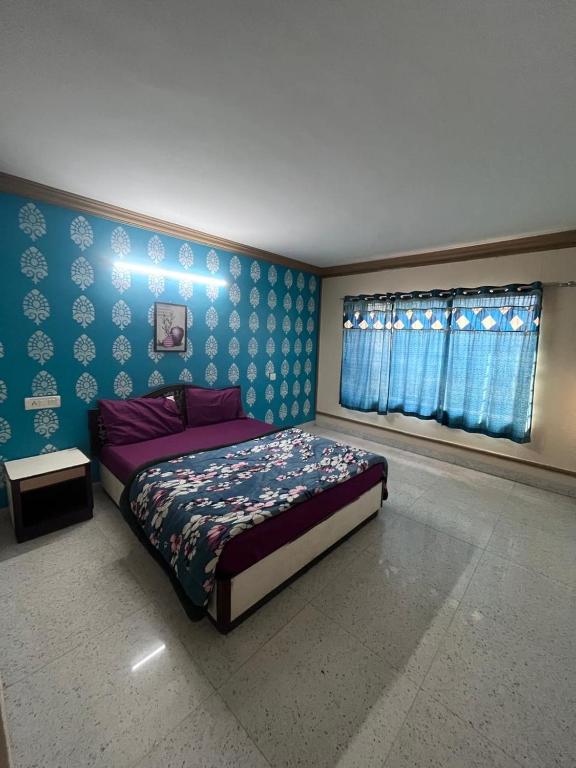 a bedroom with a bed and a blue wall at ROYAL budget Rooms in Ooty